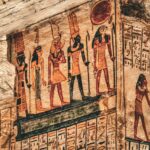 Detailed view of ancient Egyptian hieroglyphs and deities on stone temple walls, showcasing historical art.