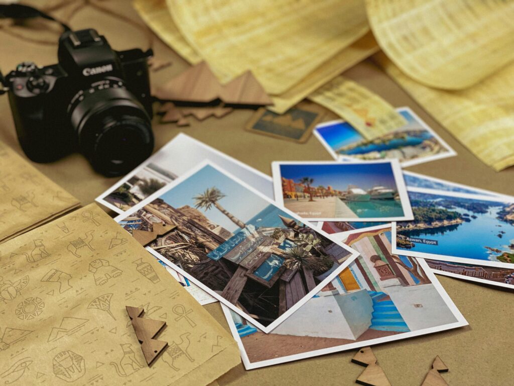 Capturing travel memories with a camera and postcards on a rustic background.