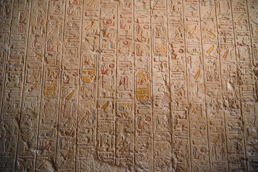 Close-up of ancient Egyptian hieroglyphs carved on temple walls, showcasing historical art.