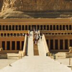 Explore the stunning architecture of the Temple of Hatshepsut against a dramatic mountain backdrop in Luxor, Egypt.