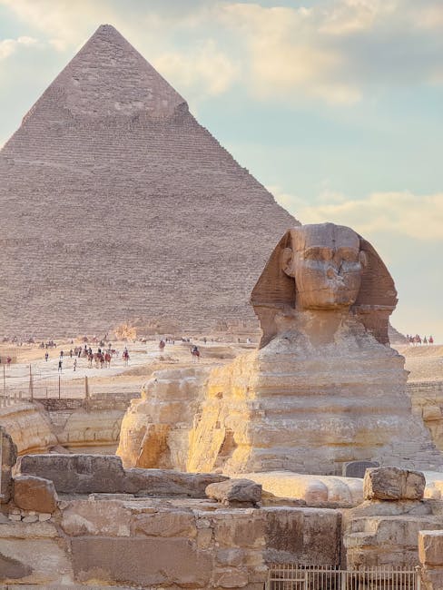 Ancient Great Sphinx with Pyramid of Giza in the background, captured at sunset.
